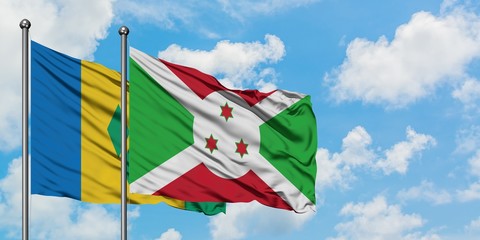 Saint Vincent And The Grenadines and Burundi flag waving in the wind against white cloudy blue sky together. Diplomacy concept, international relations.