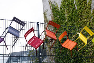 Stühle hängen an einem Zaun