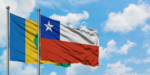 Saint Vincent And The Grenadines and Chile flag waving in the wind against white cloudy blue sky together. Diplomacy concept, international relations.