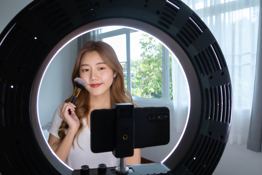 Portrait of young asian woman review giveaway gift product fan following channel, recording video make up lipstic cosmetic at home. Beauty blogger present beauty cosmetics