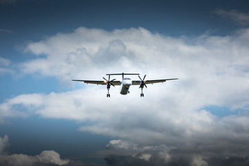 Fototapeta na wymiar Propeller airplane flying in the cloudy skies