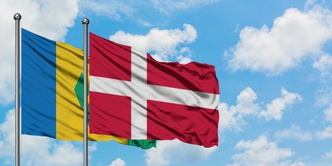 Saint Vincent And The Grenadines and Denmark flag waving in the wind against white cloudy blue sky together. Diplomacy concept, international relations.