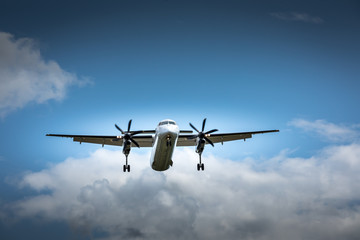 Fototapeta na wymiar Propeller airplane flying in the cloudy skies