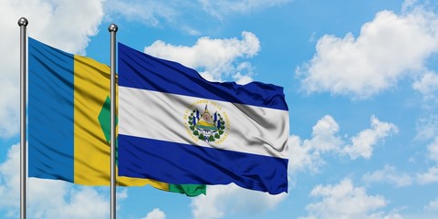 Saint Vincent And The Grenadines and El Salvador flag waving in the wind against white cloudy blue sky together. Diplomacy concept, international relations.