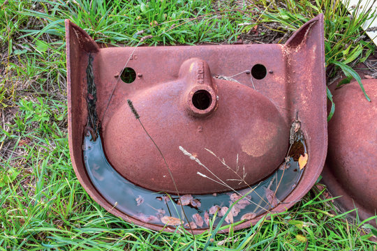 One of a  junkyard collection of rusting sinks seen turned upside down, this discarded fixture demonstrates pareidolia, the ability to see human faces in ordinary objects.