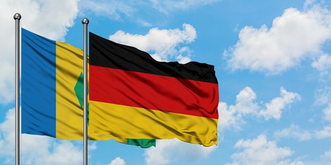 Saint Vincent And The Grenadines and Germany flag waving in the wind against white cloudy blue sky together. Diplomacy concept, international relations.