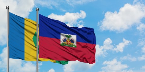 Saint Vincent And The Grenadines and Haiti flag waving in the wind against white cloudy blue sky...