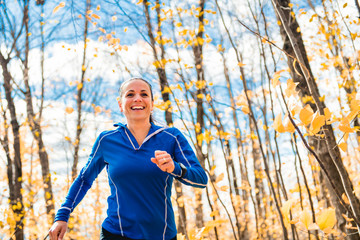 A Bautiful running woman jogging in autumn nature