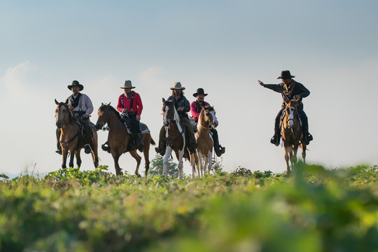 Group of Cowboy riding horse.Silhouette Cowboy on horseback.Cowboy  riding horse at sunset or sunrise time.  