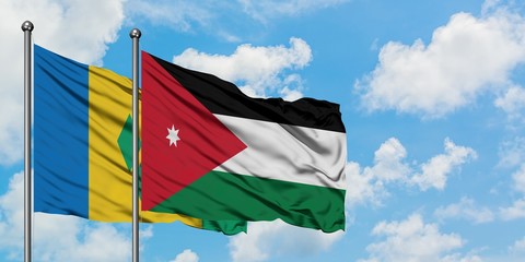 Saint Vincent And The Grenadines and Jordan flag waving in the wind against white cloudy blue sky...