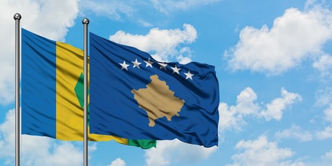 Saint Vincent And The Grenadines and Kosovo flag waving in the wind against white cloudy blue sky...
