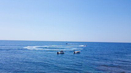 Motor boats sail on the sea. Motor boats on the sea on a Sunny day. Water fun. Happy holiday at sea. Motor boats float in a circle.