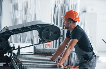 Production is on progress. Operator of machine. Industrial worker indoors in factory. Young...
