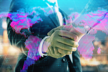 Double exposure of world map on cityscape background with two businessmen handshake. Concept of international business