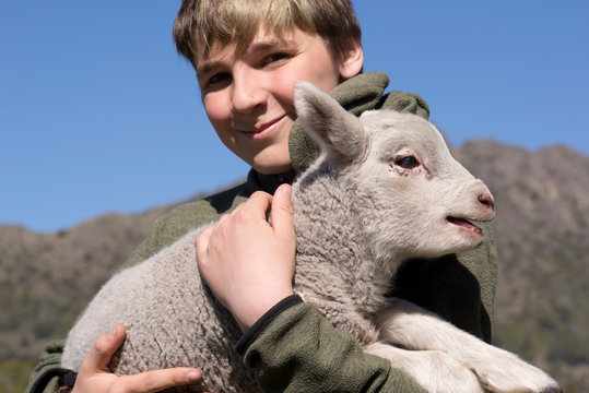 Joven en el campo cuidando a un amigo animal, su corderito. 