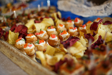 Tasty snack at the buffet table on a wooden tray.