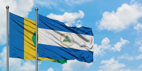 Saint Vincent And The Grenadines and Nicaragua flag waving in the wind against white cloudy blue sky together. Diplomacy concept, international relations.