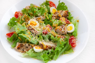 restaurant dish, salad: lettuce, chicken fillet, cherry tomatoes, quail eggs, parmesan cheese