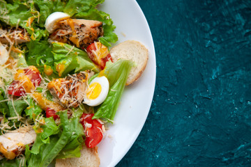 Caesar salad closeup. romaine, chicken fillet, cherry tomatoes, quail eggs, parmesan cheese, croutons