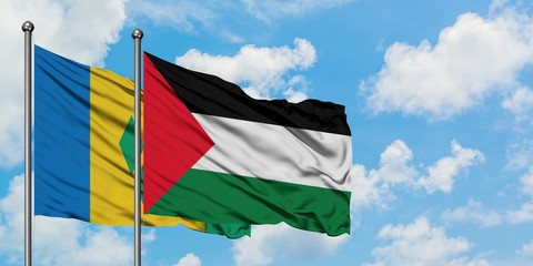 Saint Vincent And The Grenadines and Palestine flag waving in the wind against white cloudy blue...