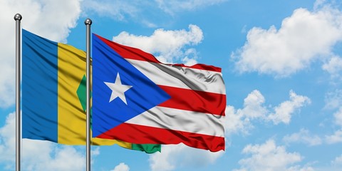 Saint Vincent And The Grenadines and Puerto Rico flag waving in the wind against white cloudy blue...