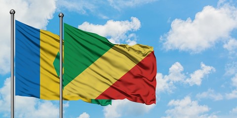 Saint Vincent And The Grenadines and Republic Of The Congo flag waving in the wind against white cloudy blue sky together. Diplomacy concept, international relations.