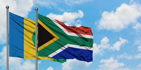 Saint Vincent And The Grenadines and South Africa flag waving in the wind against white cloudy blue sky together. Diplomacy concept, international relations.