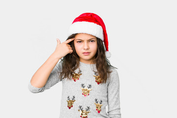 Little girl celebrating christmas day showing a disappointment gesture with forefinger.
