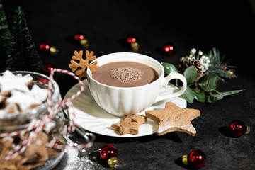 A cup of hot cocoa drink with homemade star-shaped gingerbread
