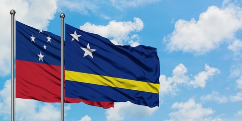 Samoa and Curacao flag waving in the wind against white cloudy blue sky together. Diplomacy concept, international relations.