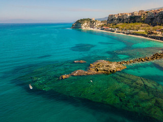 Fototapeta na wymiar Aerial view of a paddle board in the water floating on a transparent sea, snorkeling. Bathers at sea. Tropea, Calabria, Italy. Diving relaxation and summer vacations. Italian coasts, beaches and rocks