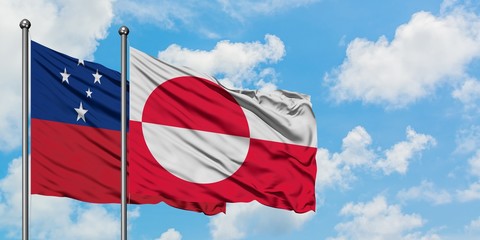 Samoa and Greenland flag waving in the wind against white cloudy blue sky together. Diplomacy...