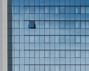 single open window on a glass facade of an office building