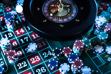 Casino background, poker Chips on gaming table, roulette wheel in motion,