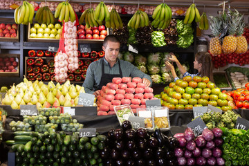 Two sellers laying out vegetables