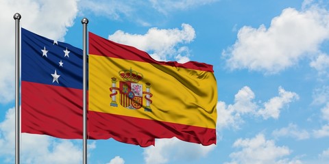 Samoa and Spain flag waving in the wind against white cloudy blue sky together. Diplomacy concept, international relations.