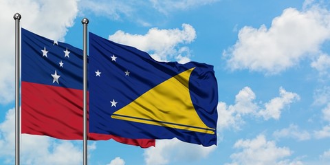 Samoa and Tokelau flag waving in the wind against white cloudy blue sky together. Diplomacy...