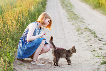 teenager girl with cat on rural road