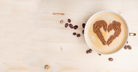 Heart shape, love symbol on hot white coffee, lover sign from cinnamon powder, on wooden surface