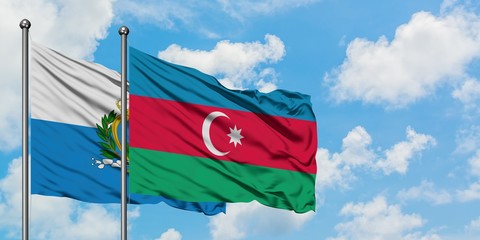 San Marino and Azerbaijan flag waving in the wind against white cloudy blue sky together. Diplomacy concept, international relations.