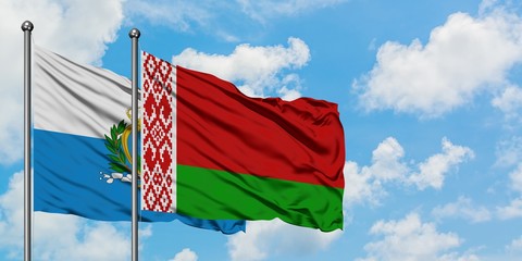 San Marino and Belarus flag waving in the wind against white cloudy blue sky together. Diplomacy...