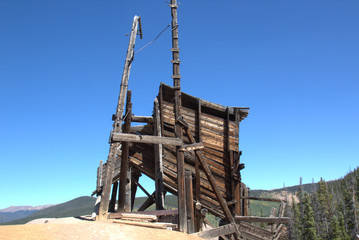 Fototapeta na wymiar Headframes are wood structures constructed over a mine shaft or winze to support pulleys used with cables and hoists for haulage and access.