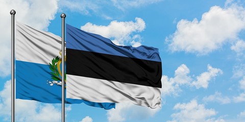 San Marino and Estonia flag waving in the wind against white cloudy blue sky together. Diplomacy...