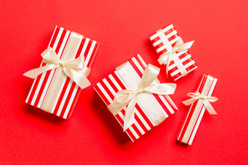 Fototapeta premium Gift box with yellow bow for Christmas or New Year day on red background, top view