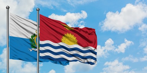 San Marino and Kiribati flag waving in the wind against white cloudy blue sky together. Diplomacy concept, international relations.