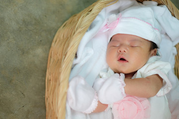 Asia newborn in white dress sleeping in basket