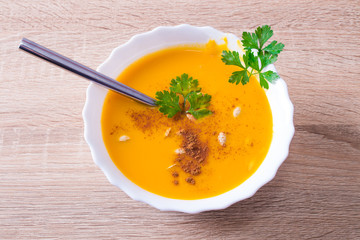 cream or pure pumpkin on plate with wooden background
