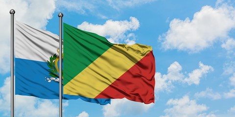 San Marino and Republic Of The Congo flag waving in the wind against white cloudy blue sky together. Diplomacy concept, international relations.