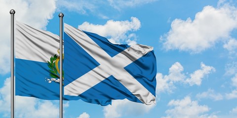 San Marino and Scotland flag waving in the wind against white cloudy blue sky together. Diplomacy concept, international relations.