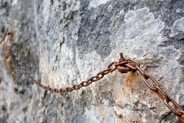 the chain is rusty on a sheer cliff for the safety of tourists